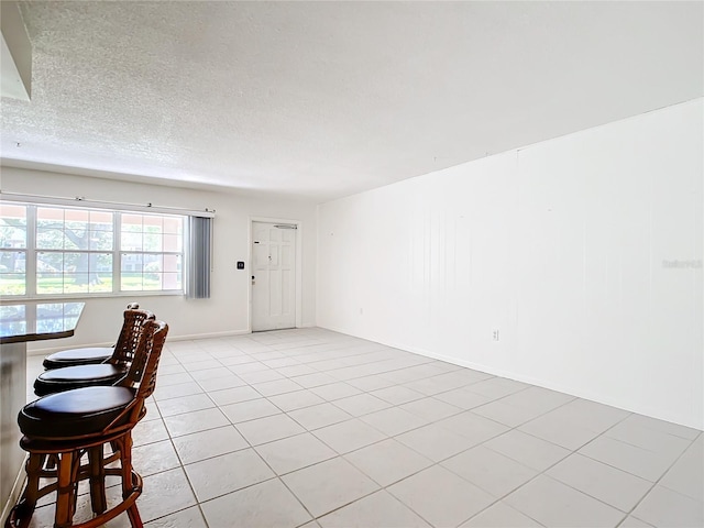 interior space featuring a textured ceiling and light tile patterned floors