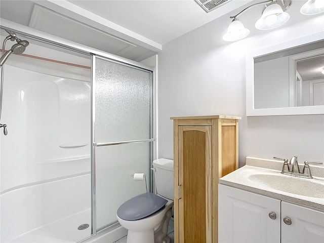 bathroom with a shower with shower door, vanity, and toilet