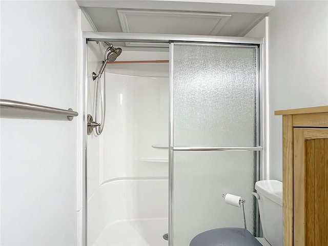 bathroom featuring a stall shower and toilet