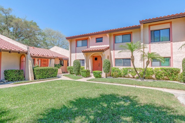 mediterranean / spanish-style house with a front yard