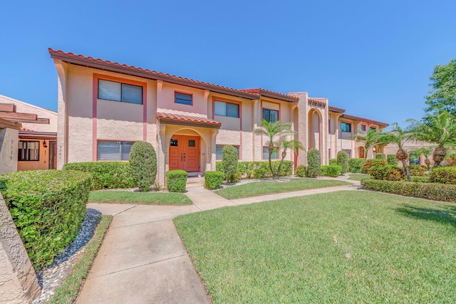 mediterranean / spanish-style home with a front lawn