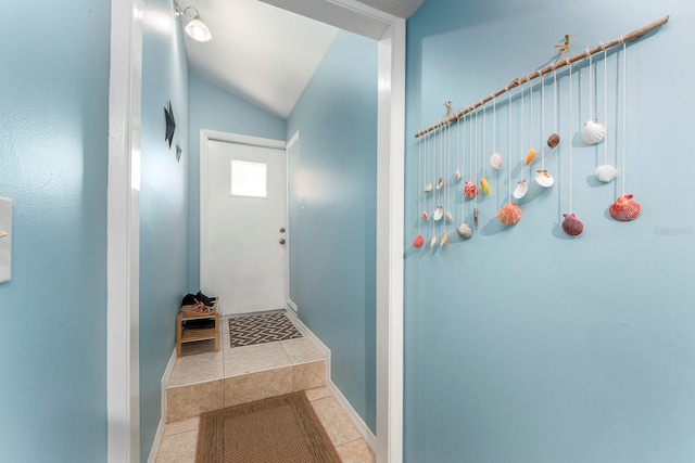 corridor with lofted ceiling and tile patterned floors