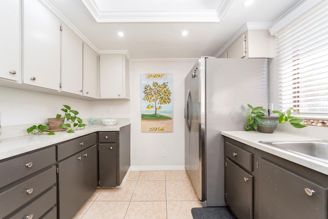 kitchen featuring white cabinets, stainless steel fridge, crown molding, and light tile patterned floors