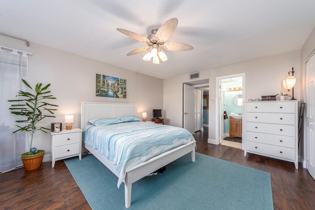 bedroom featuring ceiling fan, ensuite bath, and dark hardwood / wood-style floors