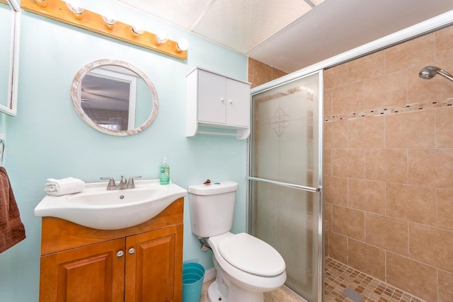 bathroom featuring an enclosed shower, vanity, and toilet