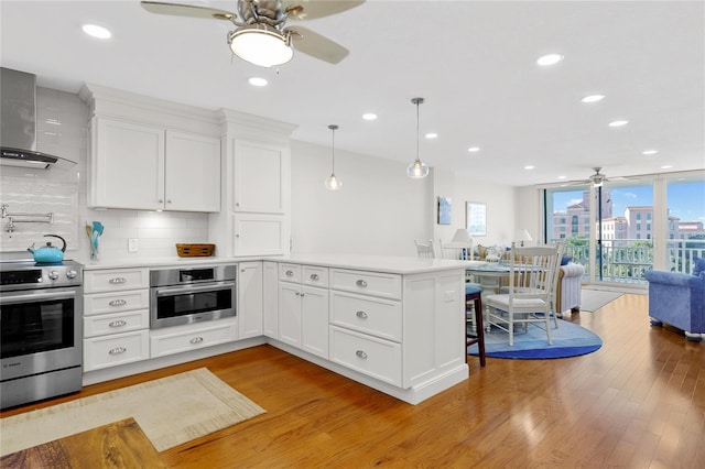 kitchen with oven, tasteful backsplash, light wood-type flooring, decorative light fixtures, and stove