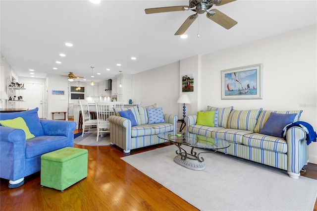 living room with dark hardwood / wood-style flooring and ceiling fan