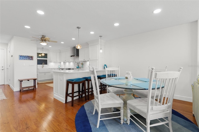 dining area featuring light hardwood / wood-style flooring, ceiling fan, and sink