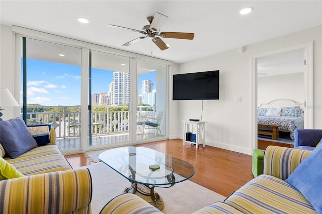 living room featuring light hardwood / wood-style floors and ceiling fan