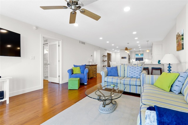 living room featuring dark hardwood / wood-style flooring and ceiling fan