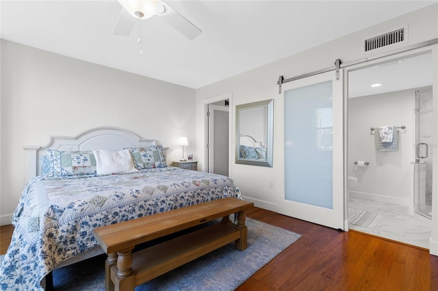 bedroom featuring connected bathroom, ceiling fan, a barn door, and dark hardwood / wood-style floors