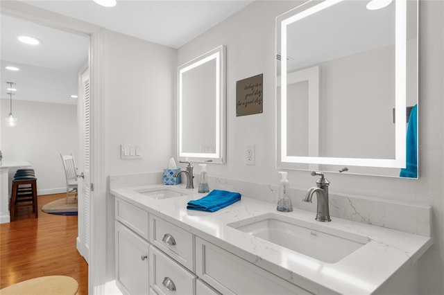 bathroom with hardwood / wood-style flooring and dual bowl vanity