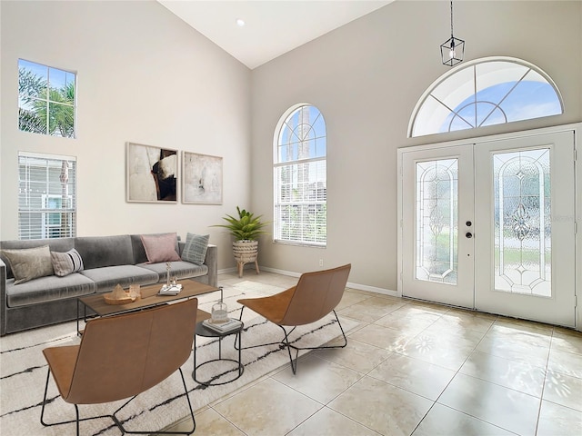 tiled living room with high vaulted ceiling and french doors