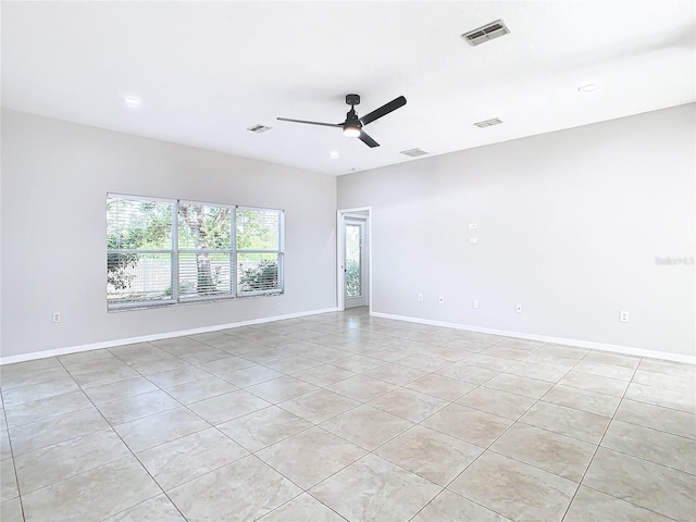 tiled empty room featuring ceiling fan and a wealth of natural light