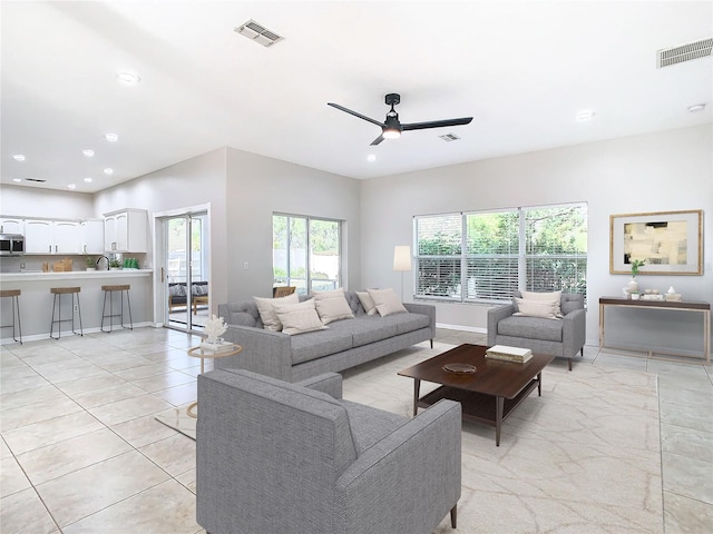 tiled living room featuring ceiling fan and sink