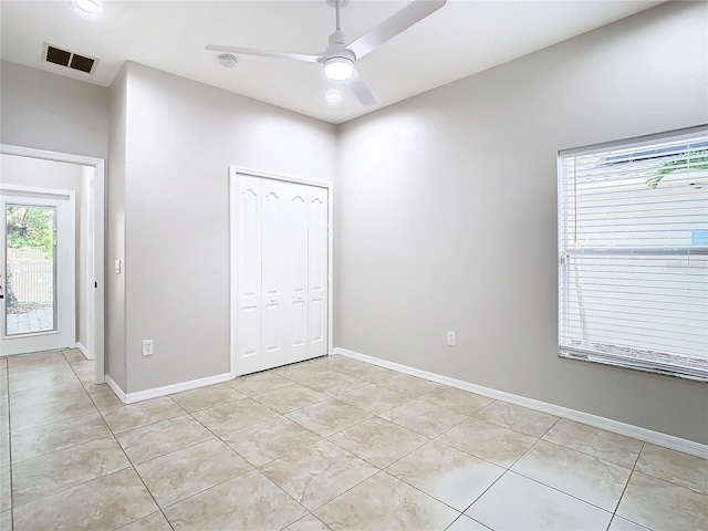 tiled empty room with ceiling fan