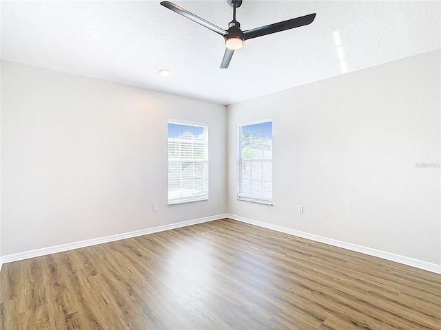 unfurnished room with ceiling fan and dark wood-type flooring