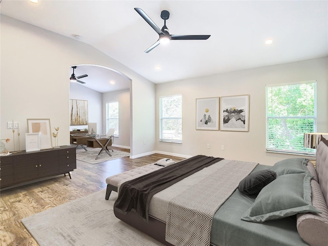 bedroom with light hardwood / wood-style flooring, vaulted ceiling, and multiple windows