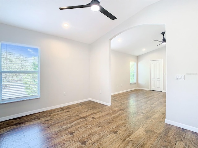 unfurnished room featuring vaulted ceiling, ceiling fan, and dark hardwood / wood-style flooring