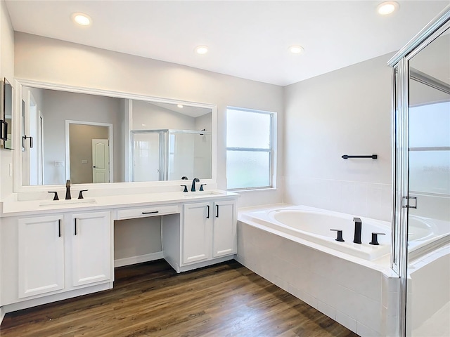 bathroom with dual bowl vanity, independent shower and bath, and hardwood / wood-style floors