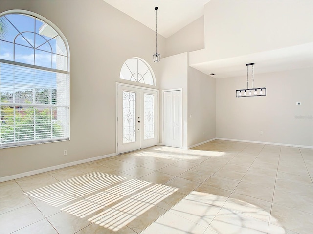 entrance foyer featuring high vaulted ceiling and light tile flooring