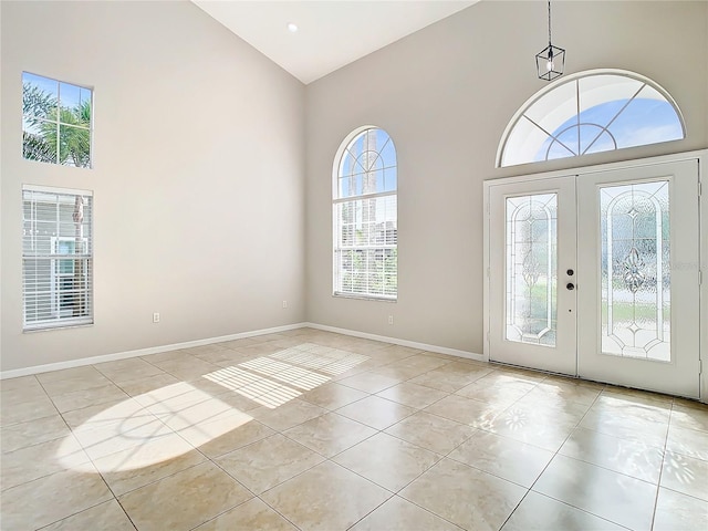 entrance foyer with high vaulted ceiling, french doors, and light tile floors