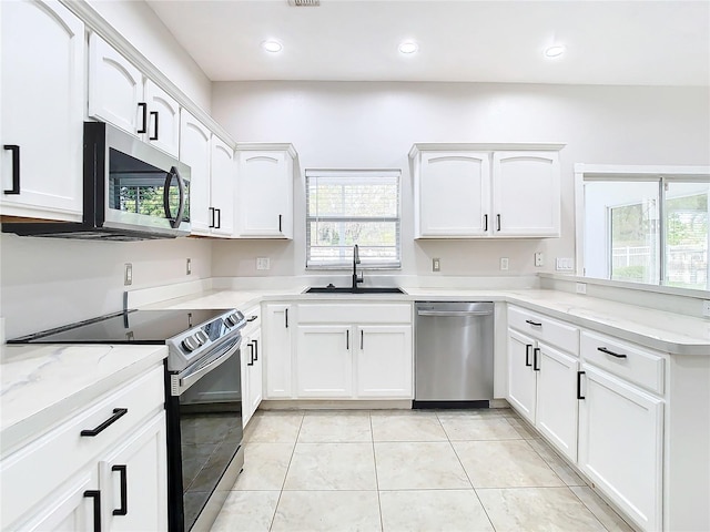 kitchen featuring white cabinets, sink, appliances with stainless steel finishes, and light tile flooring