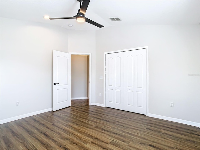 unfurnished bedroom with a closet, dark hardwood / wood-style floors, high vaulted ceiling, and ceiling fan