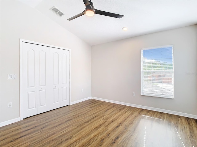 unfurnished bedroom with vaulted ceiling, ceiling fan, hardwood / wood-style floors, and a closet