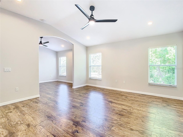 spare room featuring a healthy amount of sunlight, dark hardwood / wood-style flooring, and ceiling fan