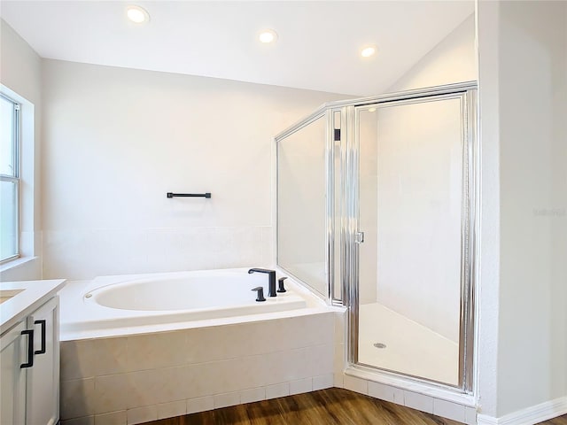 bathroom with hardwood / wood-style floors, vanity, and separate shower and tub