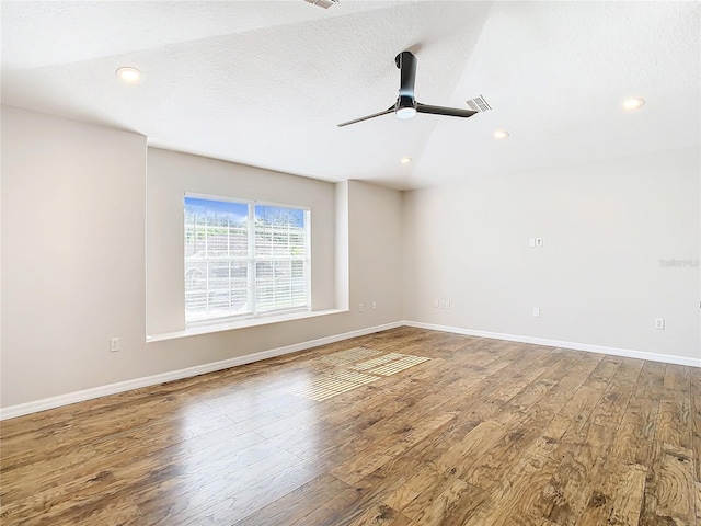 unfurnished room featuring wood-type flooring, a textured ceiling, ceiling fan, and vaulted ceiling