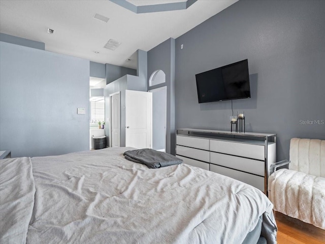 bedroom with light hardwood / wood-style floors and ensuite bathroom