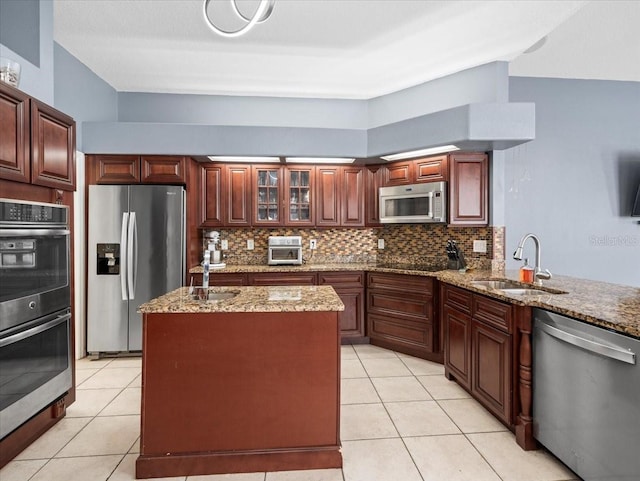 kitchen with sink, appliances with stainless steel finishes, backsplash, and light stone countertops