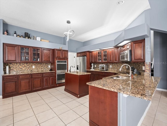 kitchen with hanging light fixtures, stainless steel appliances, sink, light tile floors, and tasteful backsplash