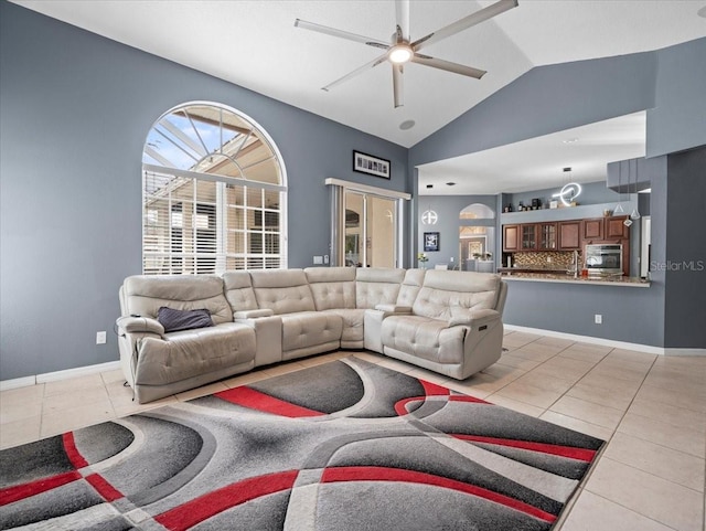 living room featuring vaulted ceiling, ceiling fan, and light tile floors