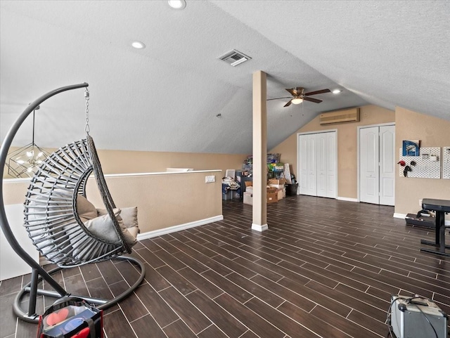 living area featuring a wall unit AC, ceiling fan, a textured ceiling, lofted ceiling, and dark hardwood / wood-style floors