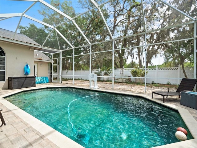 view of swimming pool featuring a patio area and glass enclosure