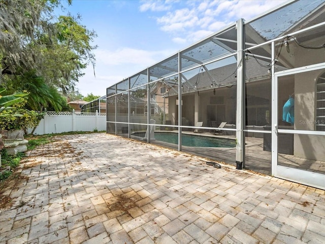 view of patio with glass enclosure and a fenced in pool