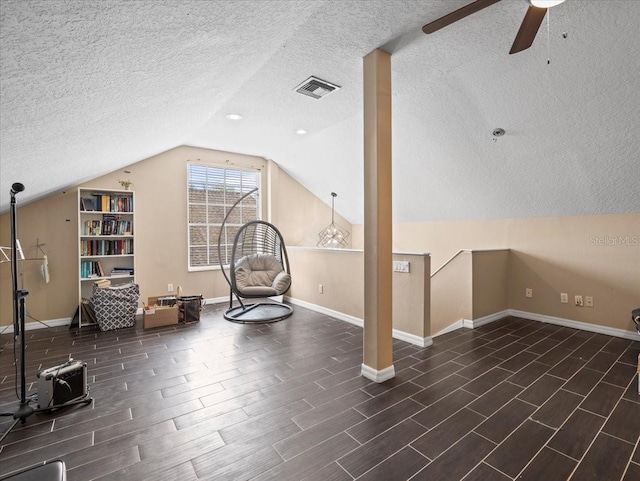 additional living space with vaulted ceiling, ceiling fan, and a textured ceiling