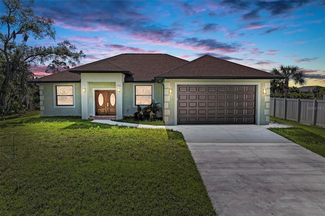 ranch-style home with a lawn and a garage