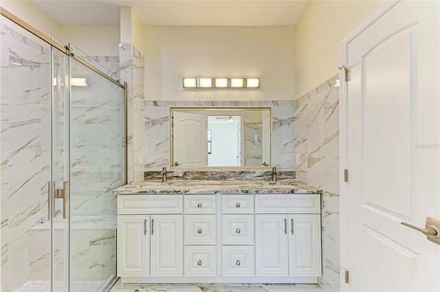 bathroom featuring vanity, tile walls, and a shower with door