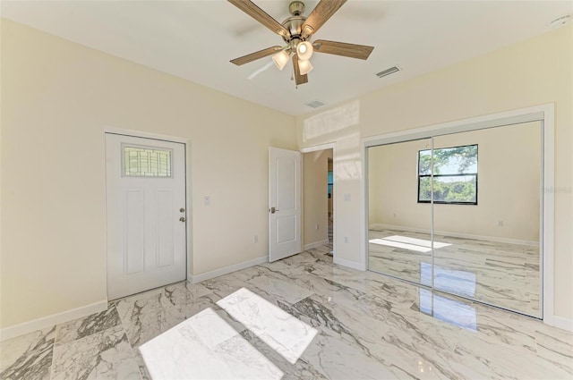 unfurnished bedroom featuring ceiling fan and a closet