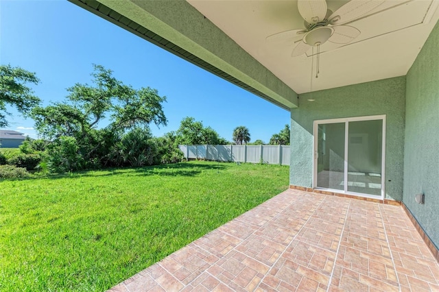 view of yard with ceiling fan and a patio