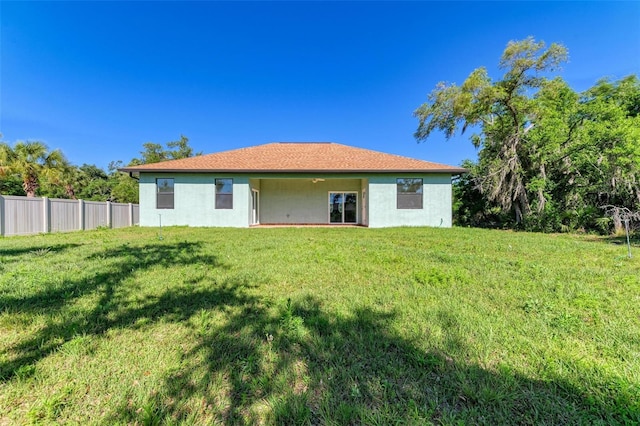 rear view of property with a yard