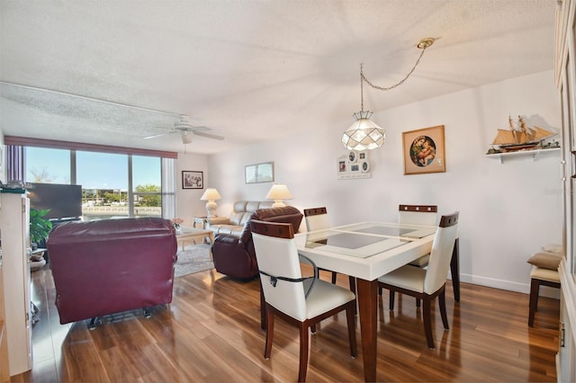 dining room with ceiling fan, a textured ceiling, and dark wood-type flooring