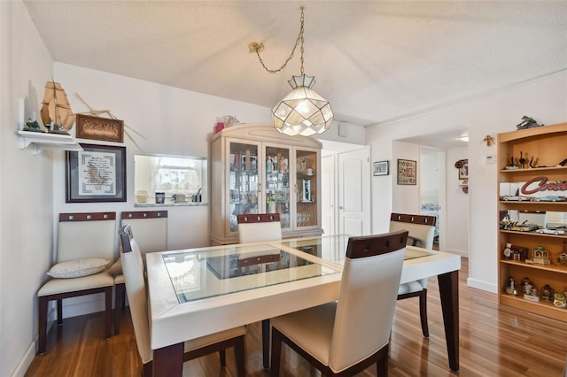 dining space featuring dark hardwood / wood-style floors and a textured ceiling