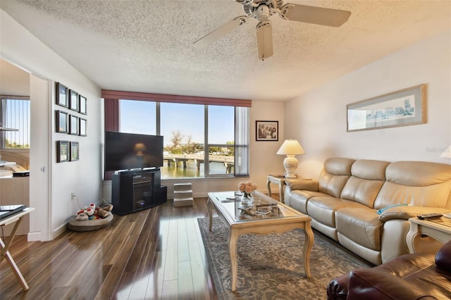 living room featuring dark hardwood / wood-style flooring, ceiling fan, a textured ceiling, and plenty of natural light