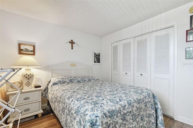 bedroom featuring wood-type flooring, a textured ceiling, and a closet