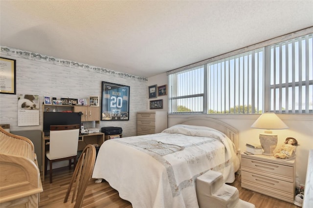 bedroom with a textured ceiling and wood-type flooring